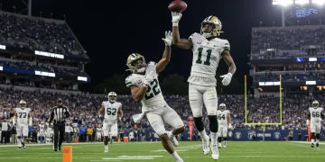 Dynamic action shot of a 2024 NFL Draft rookie making a game-changing play on the field.