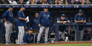 MLB manager making a strategic call in the dugout during a crucial game moment.