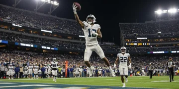 Dynamic shot of an NFL receiver making a perfect one-handed catch during Week 12, 2024 game action.