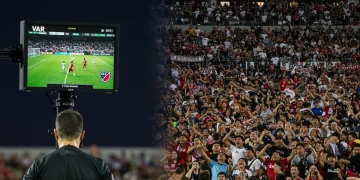 Referee reviewing VAR decision on monitor during an MLS match