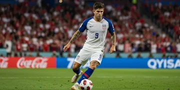 USMNT captain Christian Pulisic driving forward with the ball during a crucial World Cup qualifying match, symbolizing tactical determination.