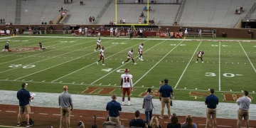 College football recruit visiting a stadium with coaches