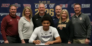 College athlete signing letter of intent during early signing period 2026 with family and coaches.