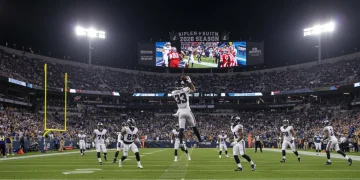 Dynamic NFL player making a shocking catch during a night game in the 2026 season.