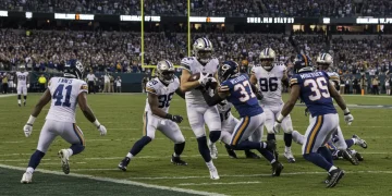 Dynamic NFL special teams kickoff return in a brightly lit stadium