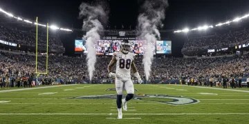 Dynamic NFL player celebrating a touchdown on a brightly lit field during the 2026 season, with fans cheering.