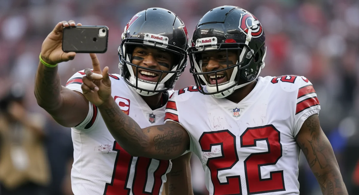 Two NFL players performing a creative, synchronized touchdown celebration with a selfie pose.